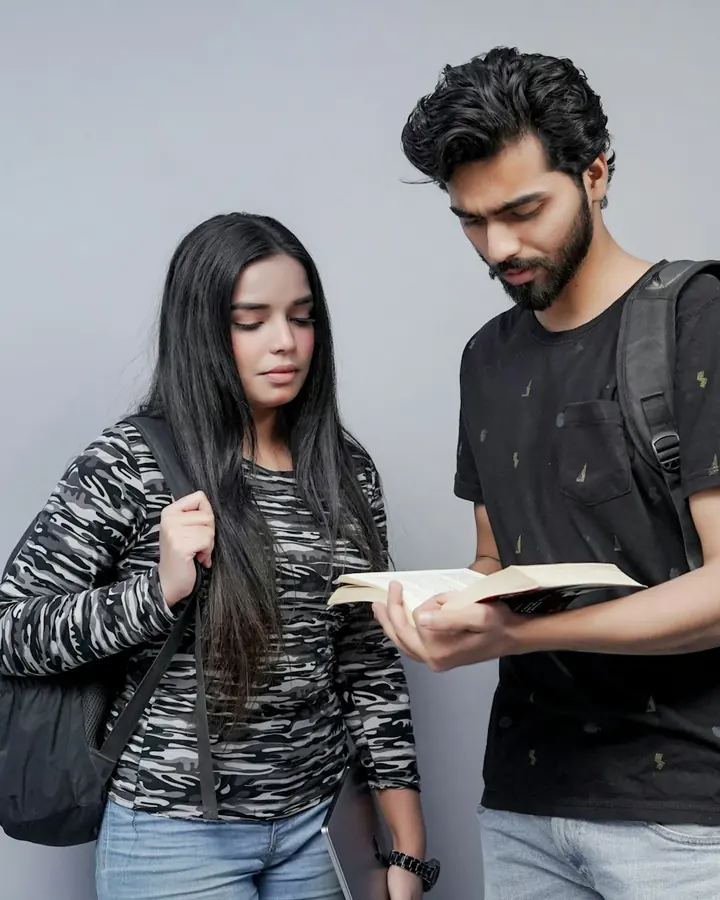 Two students looking through a book together
